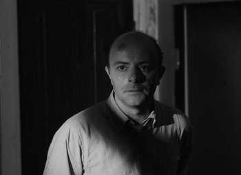 Movie still from “Night of the Living Dead” (1968), directed by George A. Romero – Black and white photograph of a man in a room; Close Up shot, Low angle