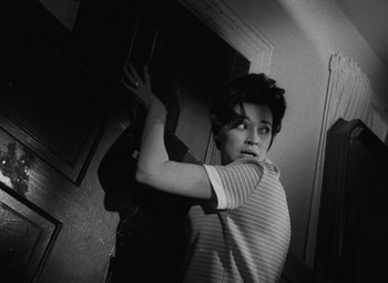 Movie still from “Night of the Living Dead” (1968), directed by George A. Romero – A young boy holding something up to his face; Medium shot, Low angle