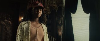 Movie still from “Nightbooks” (2021), directed by David Yarovesky – A young girl wearing a hat and a sweater; Medium shot, Low angle