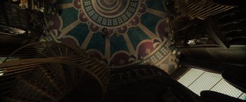 Movie still from “Nightbooks” (2021), directed by David Yarovesky – The ceiling of a building with a spiral stair case; Extreme Wide shot, Overhead angle