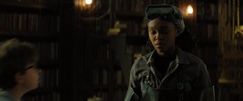 Movie still from “Nightbooks” (2021), directed by David Yarovesky – A young girl in a room with a book shelf in the background; Medium shot, Low angle