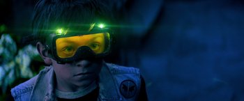 Movie still from “Nightbooks” (2021), directed by David Yarovesky – A young boy wearing goggles and a jacket; Close Up shot, Over the shoulder angle