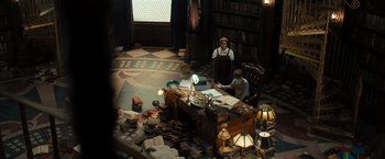 Movie still from “Nightbooks” (2021), directed by David Yarovesky – Two people sitting at a desk in a library; Wide shot, High angle