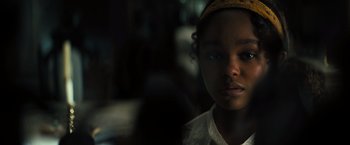 Movie still from “Nightbooks” (2021), directed by David Yarovesky – A young girl is looking into the camera; Close Up shot, Over the shoulder angle