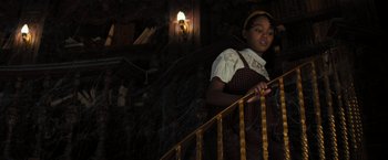 Movie still from “Nightbooks” (2021), directed by David Yarovesky – A young girl standing at the top of a stair railing; Medium shot, Low angle