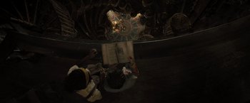 Movie still from “Nightbooks” (2021), directed by David Yarovesky – A person sitting on the ground reading a book; Extreme Wide shot, Overhead angle