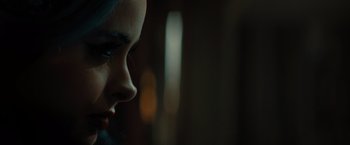 Movie still from “Nightbooks” (2021), directed by David Yarovesky – A woman's face in the dark; Extreme Close Up shot, Over the shoulder angle