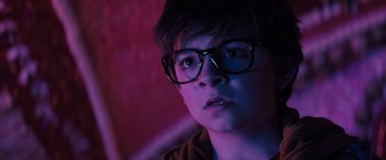 Movie still from “Nightbooks” (2021), directed by David Yarovesky – A young man wearing glasses looking into the distance; Close Up shot, Low angle