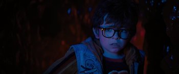 Movie still from “Nightbooks” (2021), directed by David Yarovesky – A young boy wearing glasses looking at the camera; Close Up shot, Over the shoulder angle