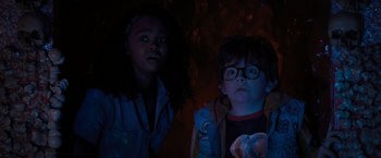 Movie still from “Nightbooks” (2021), directed by David Yarovesky – Two children are standing next to each other in the dark; Medium shot, Low angle