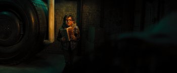 Movie still from “Nightbooks” (2021), directed by David Yarovesky – A person standing in a room holding a book; Medium shot, High angle