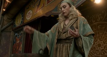 Movie still from “Nightmare Alley” (2021), directed by Guillermo del Toro – A woman dressed in medieval garb is holding something in her hand; Medium shot, Low angle