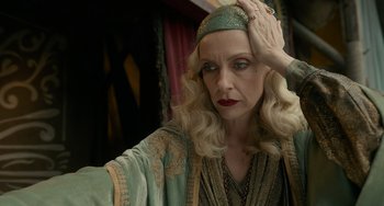 Movie still from “Nightmare Alley” (2021), directed by Guillermo del Toro – An older woman in a green and gold dress; Close Up shot, Low angle