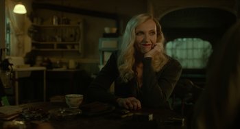 Movie still from “Nightmare Alley” (2021), directed by Guillermo del Toro – A woman sitting at a table with a cup of coffee; Medium shot, Over the shoulder angle