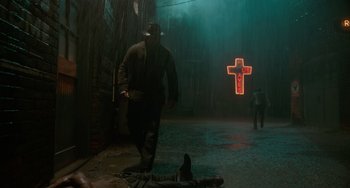 Movie still from “Nightmare Alley” (2021), directed by Guillermo del Toro – A man walking down the street in the rain; Wide shot, Low angle