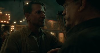 Movie still from “Nightmare Alley” (2021), directed by Guillermo del Toro – Two men standing next to each other in a dark room; Close Up shot, Over the shoulder angle