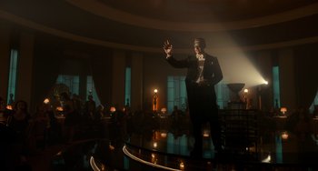 Movie still from “Nightmare Alley” (2021), directed by Guillermo del Toro – A man standing on a stage in front of a crowd; Wide shot, Low angle