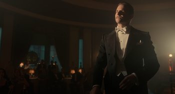 Movie still from “Nightmare Alley” (2021), directed by Guillermo del Toro – A man in a tuxedo standing in front of a crowd; Medium shot, Low angle