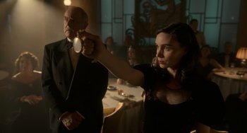 Movie still from “Nightmare Alley” (2021), directed by Guillermo del Toro – A man and a woman in a room with tables; Medium shot, Over the shoulder angle