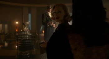 Movie still from “Nightmare Alley” (2021), directed by Guillermo del Toro – A woman standing next to a man in a room; Medium shot, Over the shoulder angle