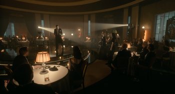 Movie still from “Nightmare Alley” (2021), directed by Guillermo del Toro – A group of people sitting at tables in a room; Extreme Wide shot, High angle
