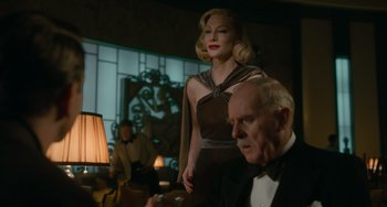 Movie still from “Nightmare Alley” (2021), directed by Guillermo del Toro – A woman in a dress and a man in a suit; Medium shot, Low angle