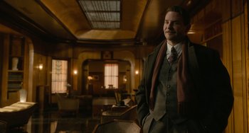 Movie still from “Nightmare Alley” (2021), directed by Guillermo del Toro – A man in a suit and tie standing in a room; Medium shot, Low angle