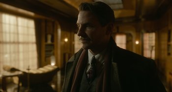 Movie still from “Nightmare Alley” (2021), directed by Guillermo del Toro – A man in a suit and tie looking to his left; Close Up shot, Low angle