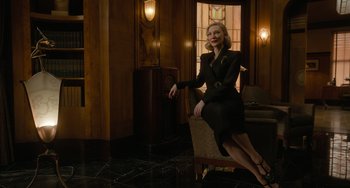 Movie still from “Nightmare Alley” (2021), directed by Guillermo del Toro – A woman sitting on a chair in front of a window; Medium shot, Low angle