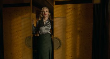 Movie still from “Nightmare Alley” (2021), directed by Guillermo del Toro – A woman standing in front of a wooden wall; Medium shot, Low angle