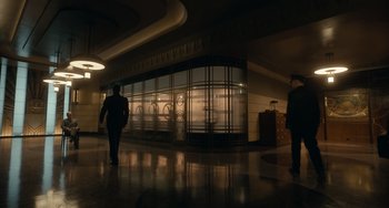 Movie still from “Nightmare Alley” (2021), directed by Guillermo del Toro – Two men are walking through a lobby at night; Extreme Wide shot, Low angle