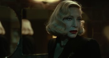 Movie still from “Nightmare Alley” (2021), directed by Guillermo del Toro – A person with blonde hair and red lipstick; Close Up shot, Over the shoulder angle