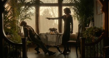 Movie still from “Nightmare Alley” (2021), directed by Guillermo del Toro – A woman sitting at a table with a glass of wine; Wide shot, Low angle