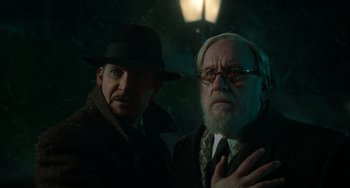 Movie still from “Nightmare Alley” (2021), directed by Guillermo del Toro – A man and an older man standing next to each other; Close Up shot, Over the shoulder angle
