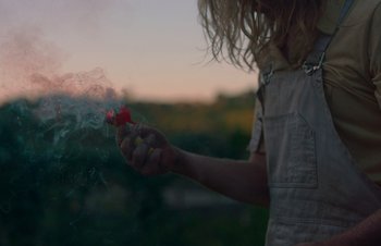 Movie still from “Nitram” (2021), directed by Justin Kurzel – A person holding a smoke bomb in their hand; Extreme Close Up shot, High angle