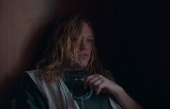Movie still from “Nitram” (2021), directed by Justin Kurzel – A person with long hair is holding a phone; Close Up shot, Low angle