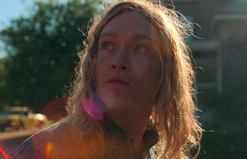 Movie still from “Nitram” (2021), directed by Justin Kurzel – A person with long blonde hair; Close Up shot, Low angle