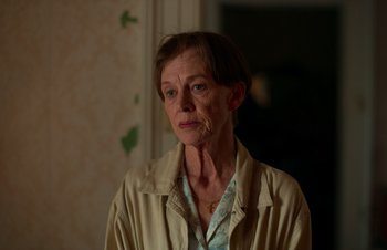 Movie still from “Nitram” (2021), directed by Justin Kurzel – An older woman is looking at the camera; Close Up shot, Over the shoulder angle