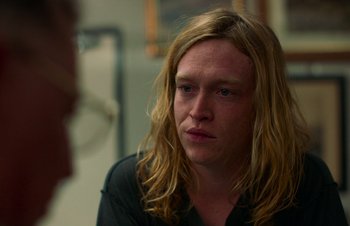 Movie still from “Nitram” (2021), directed by Justin Kurzel – A person with long blonde hair; Close Up shot, Over the shoulder angle