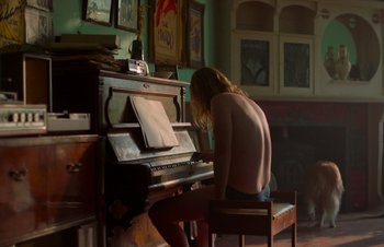 Movie still from “Nitram” (2021), directed by Justin Kurzel – A man sitting in front of an upright piano; Medium shot, Low angle