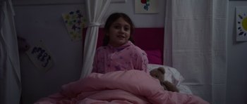 Movie still from “Nix” (2022), directed by Anthony C. Ferrante – A little girl in a bed with a teddy bear; Medium shot, High angle