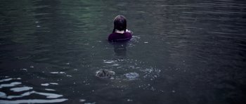 Movie still from “Nix” (2022), directed by Anthony C. Ferrante – A woman in a purple shirt is in the water; Medium shot, High angle