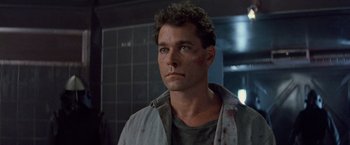 Movie still from “No Escape” (1994), directed by Martin Campbell – A person wearing a jacket; Close Up shot, Low angle