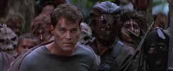Movie still from “No Escape” (1994), directed by Martin Campbell – A man with a mask and a helmet is looking at the camera; Close Up shot, Over the shoulder angle