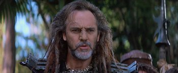 Movie still from “No Escape” (1994), directed by Martin Campbell – A person with dreadlocks; Close Up shot, Low angle