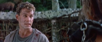 Movie still from “No Escape” (1994), directed by Martin Campbell – A person wearing a shirt with blood all over it; Close Up shot, Low angle