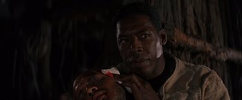 Movie still from “No Escape” (1994), directed by Martin Campbell – A man is shaving another man's face; Close Up shot, Over the shoulder angle