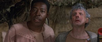 Movie still from “No Escape” (1994), directed by Martin Campbell – A man and a woman standing next to each other; Close Up shot, Low angle