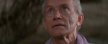 Movie still from “No Escape” (1994), directed by Martin Campbell – An older man with blue eyes looking upward; Close Up shot, Low angle