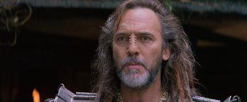 Movie still from “No Escape” (1994), directed by Martin Campbell – A person with long hair; Close Up shot, Low angle